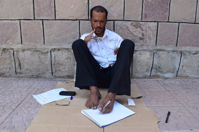 رجل يمني ولد بغير ذراعين ولديه القدرة على الكتابة بقدميه وتلبية احتياجاته ومواجهة واقعه في منطقة حرب (صور) 